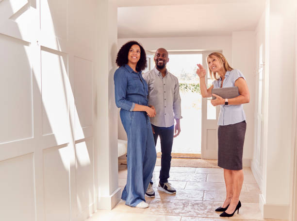 couple viewing potential new home with female real estate agent - exploration imagens e fotografias de stock