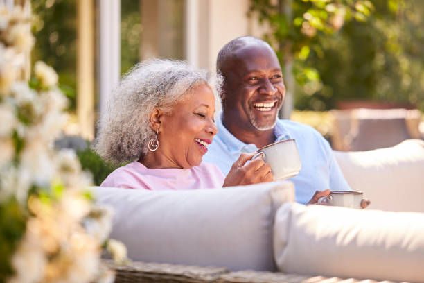 pareja de jubilados sentados al aire libre en casa tomando café por la mañana juntos - 60 65 años fotografías e imágenes de stock