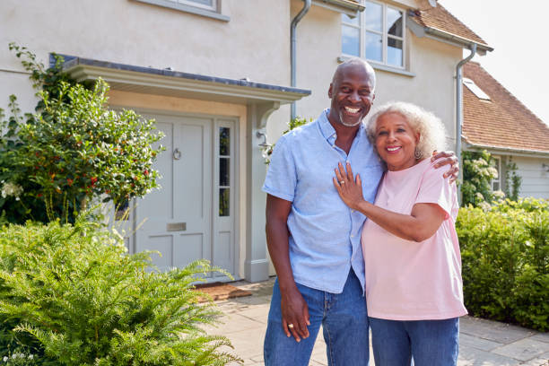 Portrait Of Smiling Senior Couple Standing Outside Home Together Portrait Of Smiling Senior Couple Standing Outside Home Together 60 69 years stock pictures, royalty-free photos & images