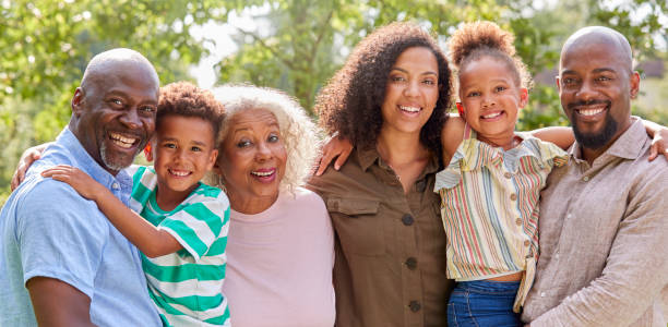 porträt der lächelnden mehrgenerationenfamilie zu hause im garten zusammen - multi generation family stock-fotos und bilder