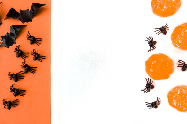 istock Halloween holiday. Flatly on a white and orange baackground. Bats and spiders. Copyspace 1339019151