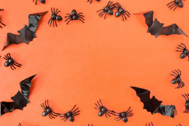 istock Halloween holiday. Flatly on an orange background. Bats and spiders. Copyspace. Postcard with frame 1339019667