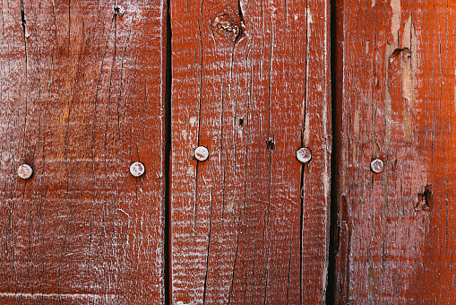 old red wooden boards with cracked and peeling paint. Background and texture