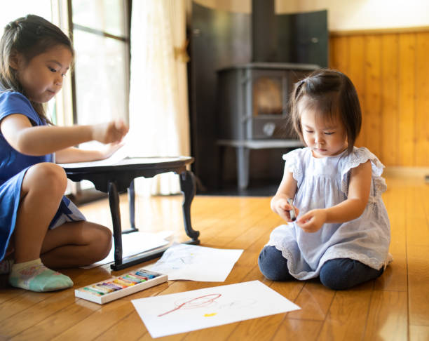 istock Young girls drawing with crayons on paper 1339020181