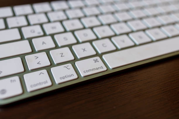 Low angle view of a computer keyboard with selective focus to the Enter key and copy space to the right