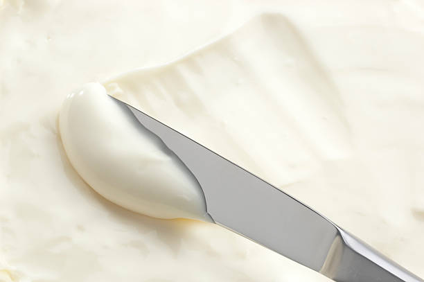 A knife swiping into some cream cheese