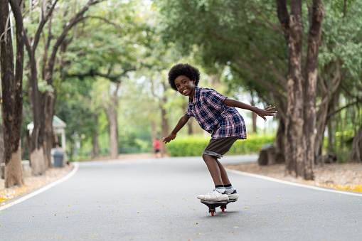 modern woman riding skateboard in city and wearing safety helmet