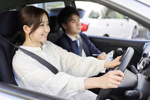 A woman taking a car driving lesson