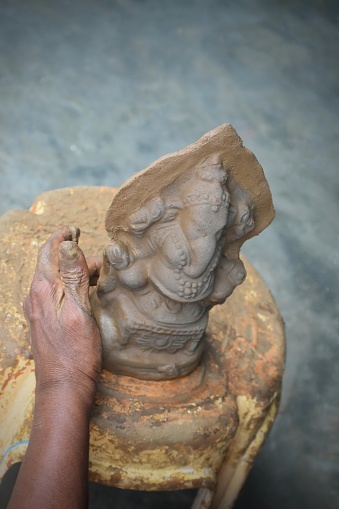 Close up, Ganesha clay design pottery. Ganesha shape clay craft hand made. Pottery artisan use two hands to sculpt the Ganesha with meticulousness.ganesh chaturthi, india.