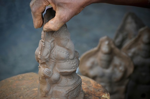 Close up, Ganesha clay design pottery. Ganesha shape clay craft hand made. Pottery artisan use two hands to sculpt the Ganesha with meticulousness.ganesh chaturthi, india.