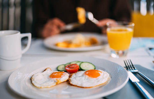 Enjoying orange juice and breakfast in a restaurant outdoor.