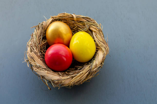 istock three painted eggs easter decor in a basket nest yellow, gold and red 1339026417