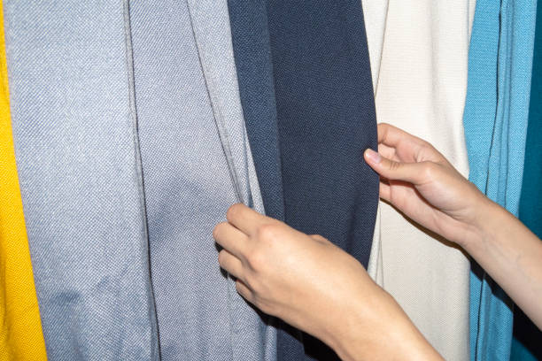 istock Female hands choosing multicolored fabric for sewing curtains, interior design in the store. Seasonal sale concept 1339027044
