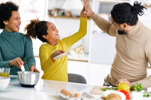 istock Happy black family having fun while making pancakes in the kitchen. 1339027296