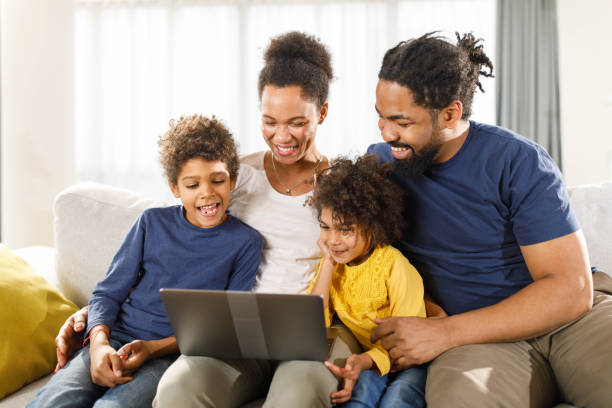istock Happy black family using laptop on sofa at home. 1339027688