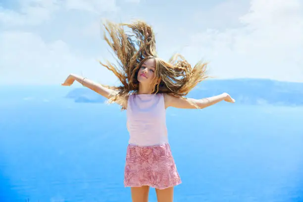 Blond girl shaking hair on air at blue Mediterranean sea tourist in Spain