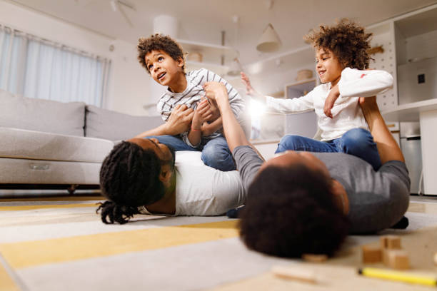 istock Happy black family playing on floor at home. 1339027802