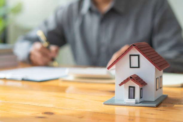 Property investment concept, image of small house model on the table.and home loan insurance. Property investment concept, image of small house model on the table.and home loan insurance. estate worker stock pictures, royalty-free photos & images