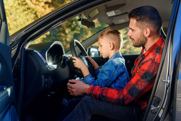istock handsome father pointing on something while teaching teen son driving car 1339028875