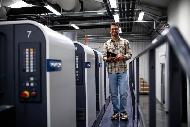 istock Shot of a professional graphic designer checking print quality on modern offset printing machine. 1339029973