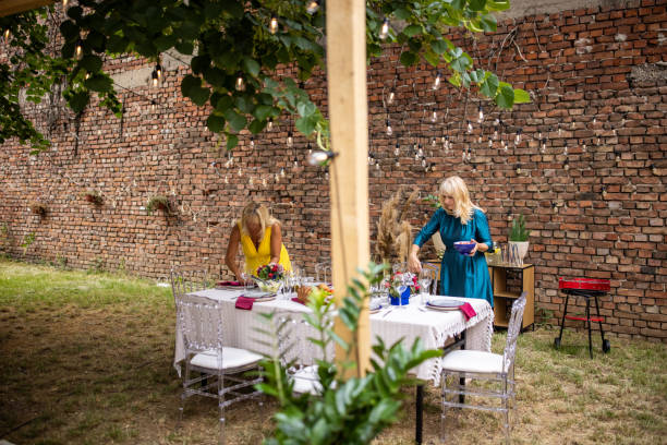 istock Friends setting dining table for garden party at backyard 1339031436