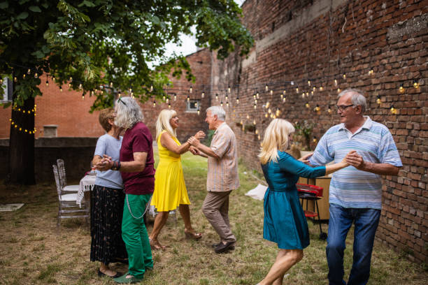 istock Senior friends dancing and having fun time on reunion party at backyard 1339032721