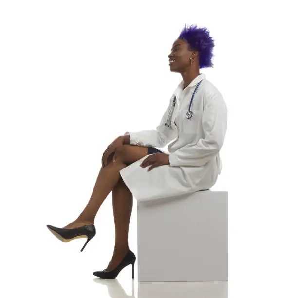 Photo of Side View Of Black Female Doctor Sitting On White Box