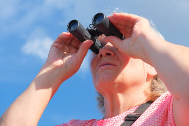 istock Low angle view of a senior woman with binoculars outdoors, birdwatching 1339034278
