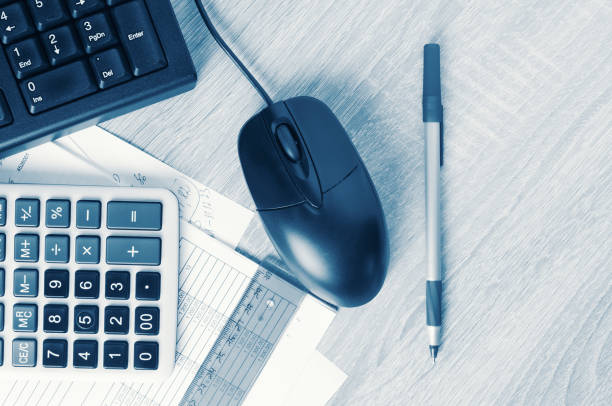 Business workspace desk with pc keyboard, calculator and accounting paper. Toned image