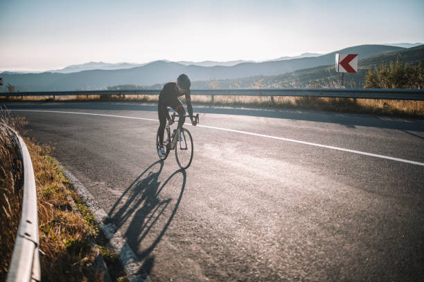 Male Cyclist Driving Up Mountain Road. stock photo