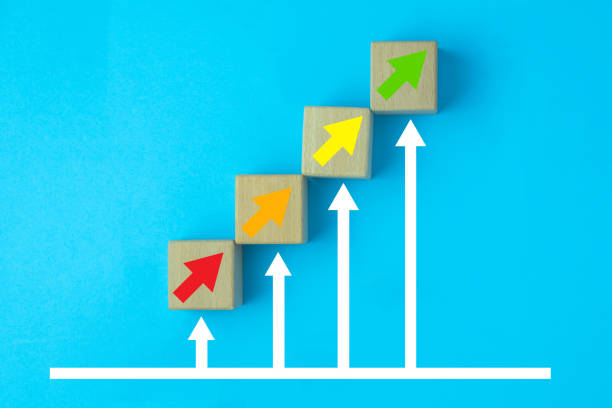 istock Personal development and Career growth concept, Wooden cubes stacking as step stair with red arrow, Orange arrow, yellow arrow and green arrow up on blue background. 1339036943