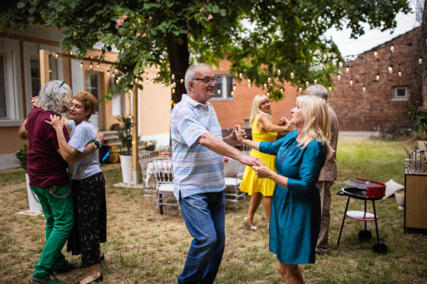 istock Senior couples spending fun time together dancing on party in backyard on summer day 1339037284