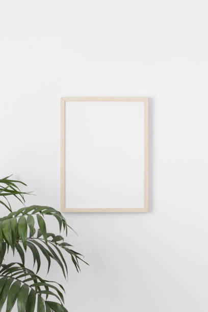 istock Wooden frame mockup on the wall with a palm plant. 1339037336