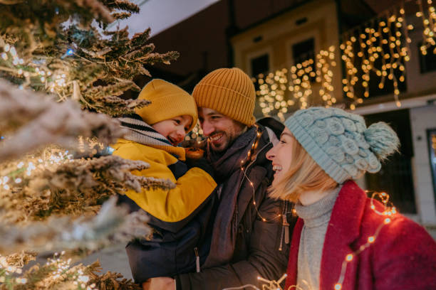 Celebrating Christmas outdoors with our son Photo of a young family celebrating Christmas outdoors family christmas stock pictures, royalty-free photos & images