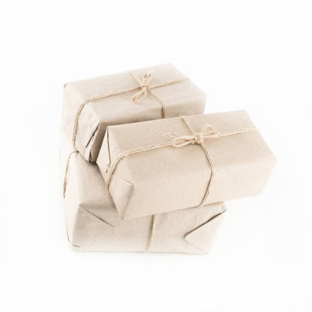 stack of giftbox in plain brown paper tied with twine on isolated background - 11911 imagens e fotografias de stock