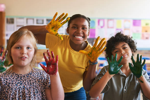 ujęcie zróżnicowanej grupy dzieci stojących razem w klasie w szkole z pomalowanymi rękami - child art and craft latin american and hispanic ethnicity little boys zdjęcia i obrazy z banku zdjęć