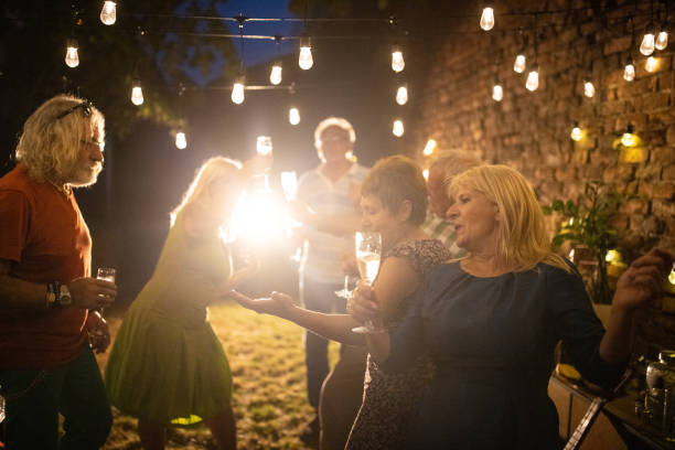 istock Senior people having fun and dancing on garden party at night 1339041369