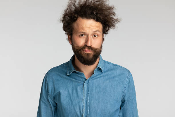 istock casual relaxed young man with curly hair making funny faces 1339043438