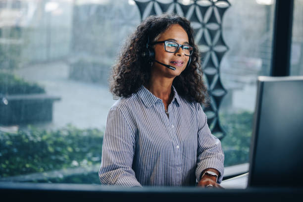 woman call center executive at work - african descent customer service representative computer service imagens e fotografias de stock