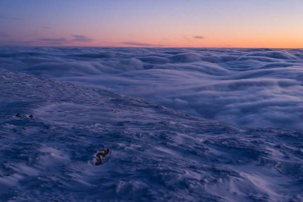 istock View from top of winter highlands at twilight with clouds below 1339047384