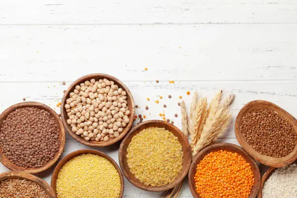 Gluten free cereals. Rice, buckwheat, corn groats, quinoa and millet in wooden bowls. Top view flat lay with copy space