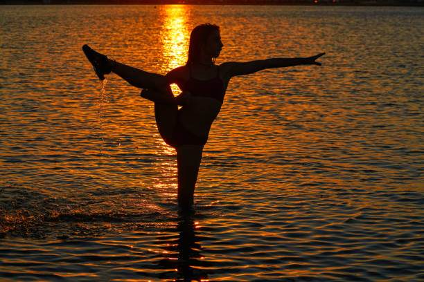 istock Girl gymnastics pose at sunset beach 1339048479
