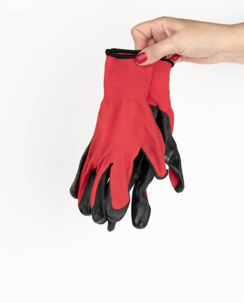 istock female hand holds textile red work gloves on a white background. Protective clothing for manual workers 1339050504