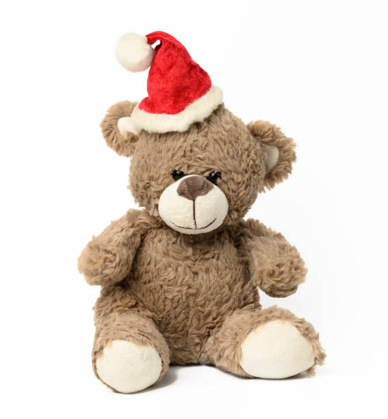 istock cute brown teddy bear sitting in red christmas cap on white  background 1339050531