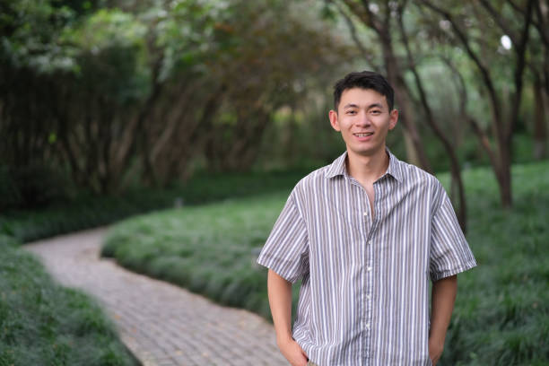 istock Asian young man smiling at natural green park 1339051342