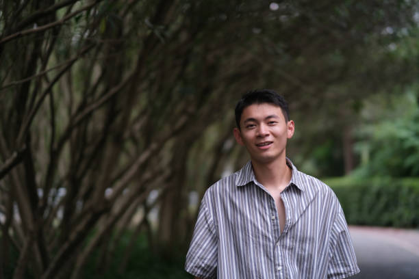istock smiling Asian young man in natural park 1339051365