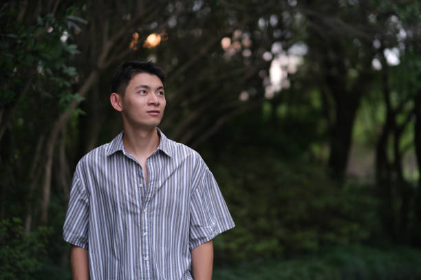 istock Handsome Asian young man in park 1339051366