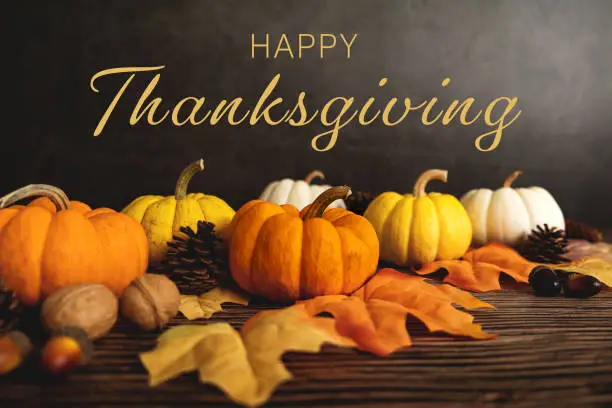 Photo of Happy Thanksgiving Day with pumpkin and nut on wooden table