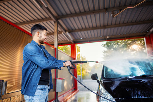 istock Man washes the car with a hose before going on the road 1339051416