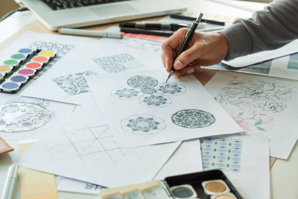 istock Designer designing drawing sketch pattern geometric flower seamless wallpaper fabric textile fashion industry. artistic design studio. 1339054063